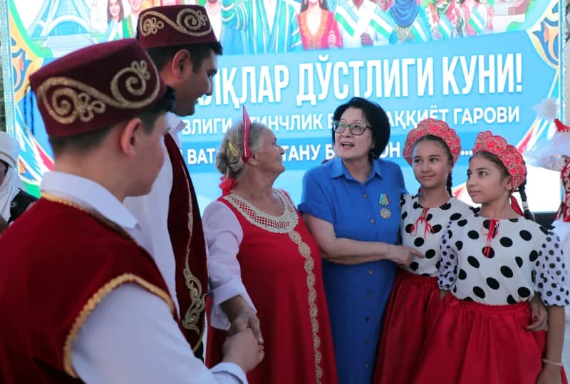 Люди в традиционной одежде и повседневной одежде общаются на открытом воздухе