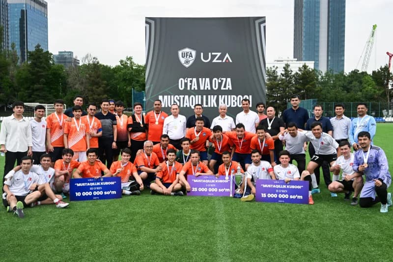 Kuboklar va bannerlar bilan futbol jamoalarining guruh surati