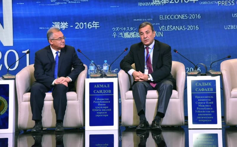 Two men seated at a panel discussion