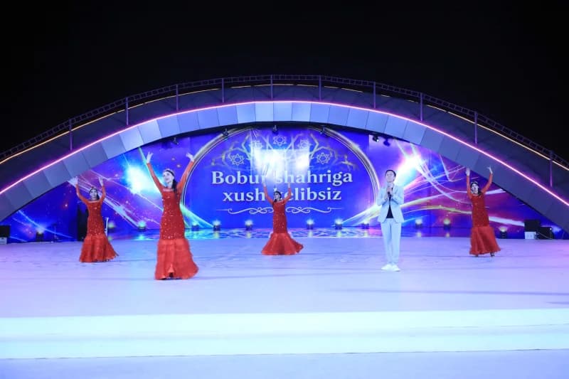 Performers on illuminated outdoor stage during event