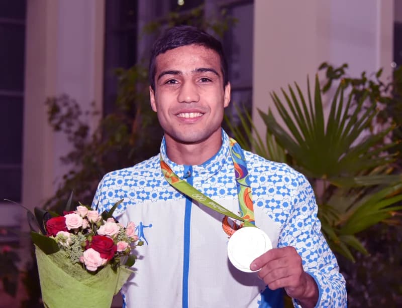 Qoʻlida medal va guldasta ushlagan sportchi portreti