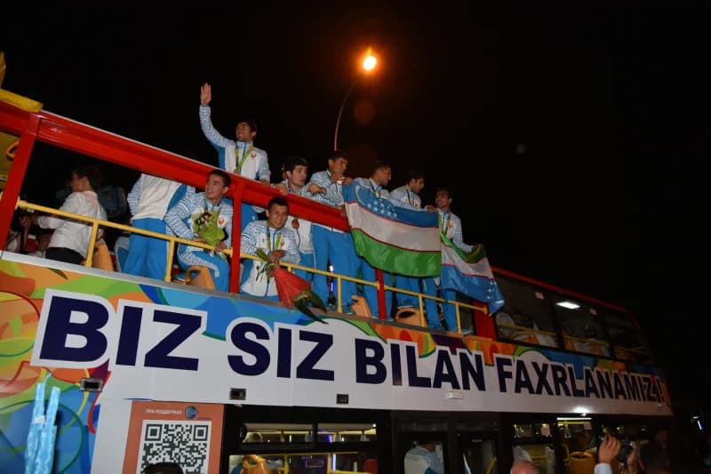 Group of athletes riding on top of a bus at night