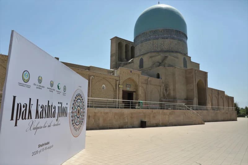 Ochiq havoda koʻk gumbazli va reklama bannerli tarixiy meʼmoriy yodgorlik