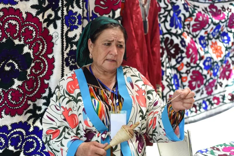 Naqshli matolardan oldin shpindel bilan ishlayotgan ayol