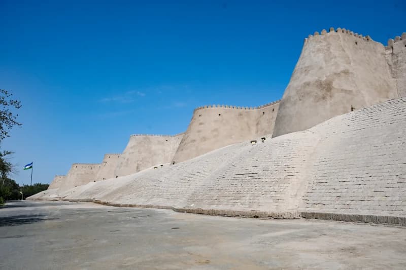 Ancient defensive mud-brick fortress wall against clear blue sky