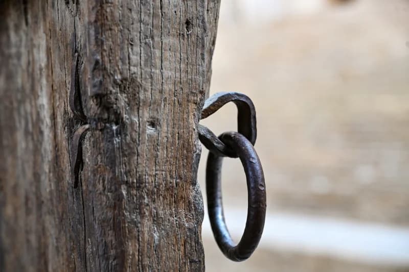 Close-up of an old metal ring attached to a wooden beam