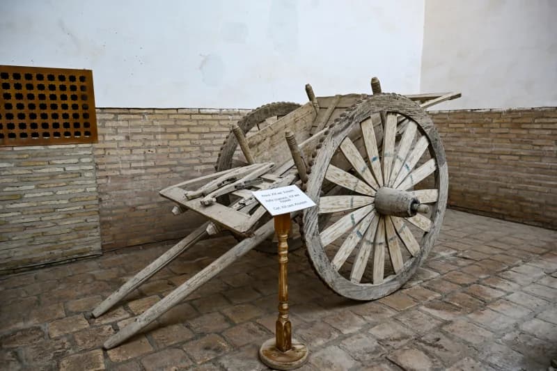 Old wooden cart inside a building with brick walls