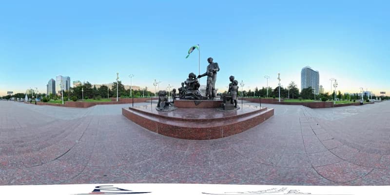 Bronze monument sculpture group on public square with flag