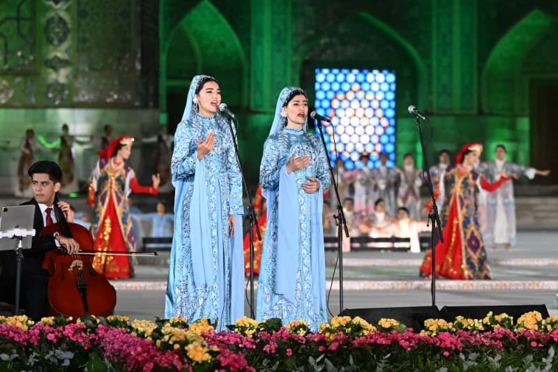 Исполнители, поющие на сцене во время культурного мероприятия на открытом воздухе