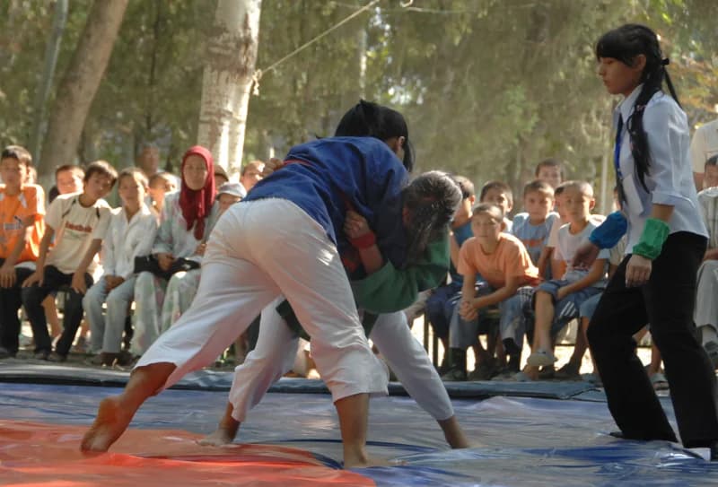 Athletes wrestling outdoors during a competition