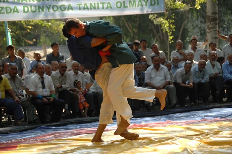 Wrestlers competing in a match before spectators