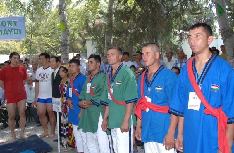 Спортсмены в традиционной спортивной одежде стоят на улице во время соревнований.