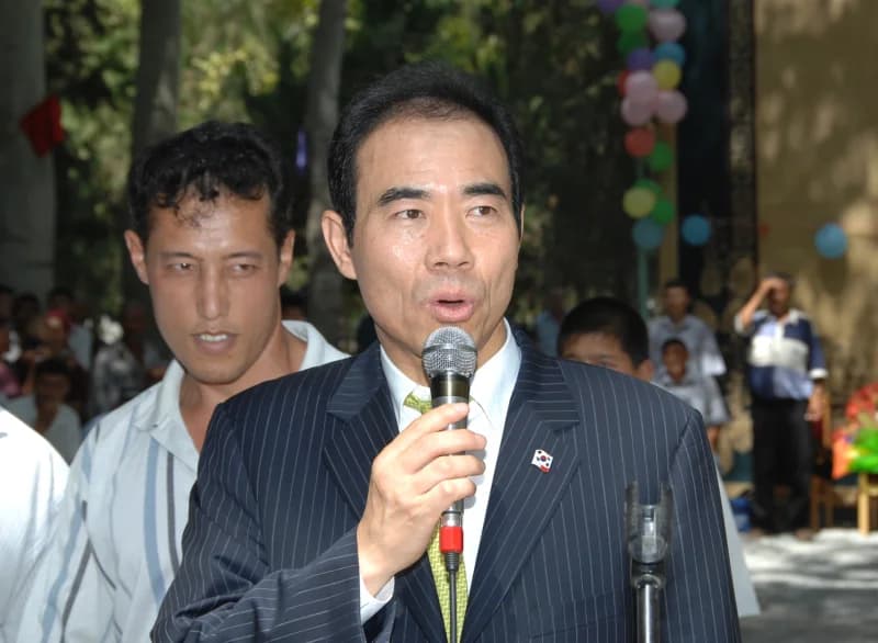 Man speaking into a microphone outdoors