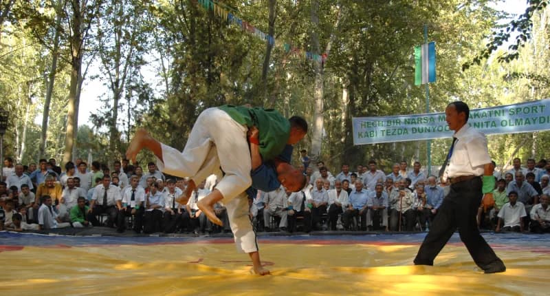 Athletes competing in a wrestling match outdoors