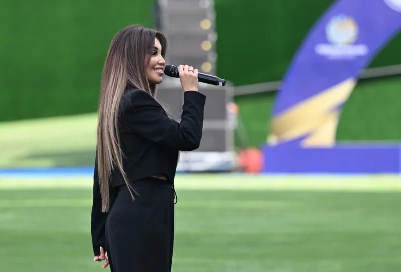 Person singing into a microphone on stage