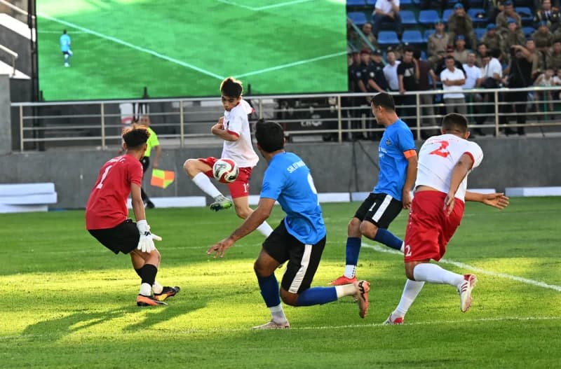 Players compete during a football match on a grass field