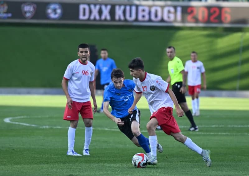 Players competing in a football match on a grass field