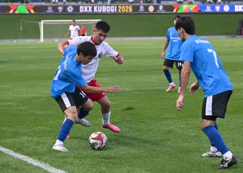 Players competing for the ball during a football match on a grass field