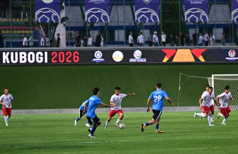 Athletes competing in a football match on a grass field