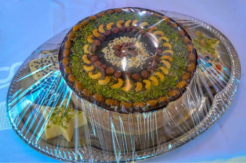 Round decorated cake with nuts on a tray