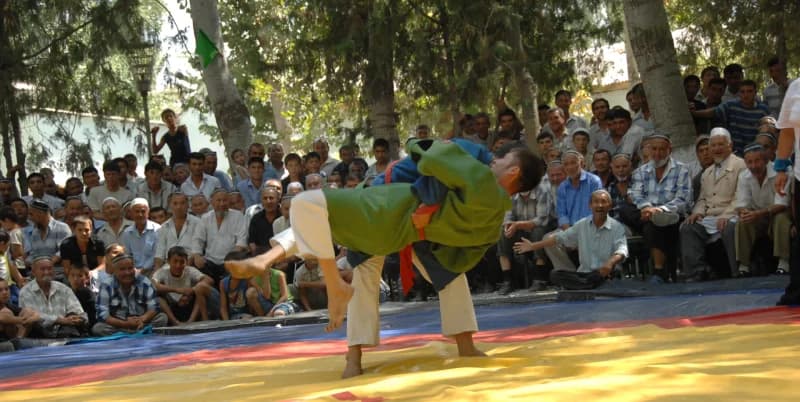 Wrestlers competing on a mat outdoors