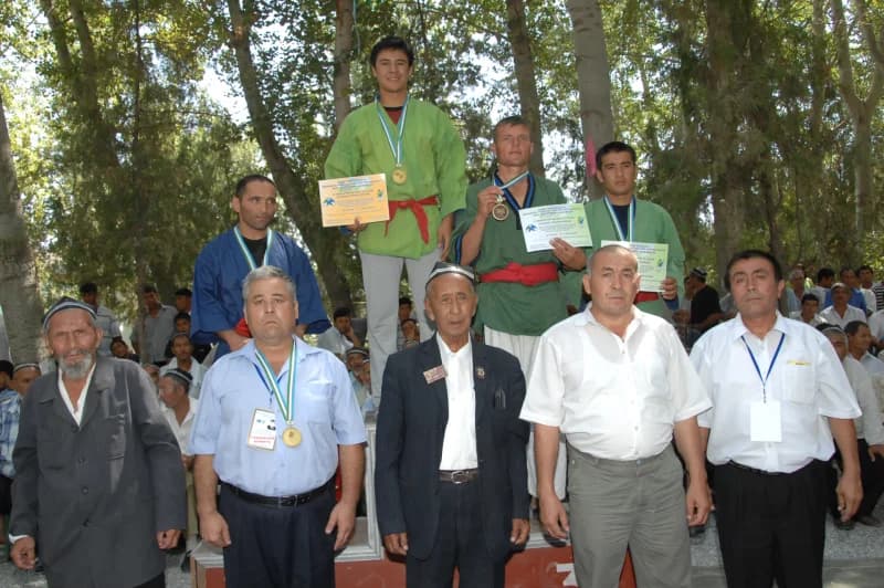 Athletes standing on a podium with medals and certificates
