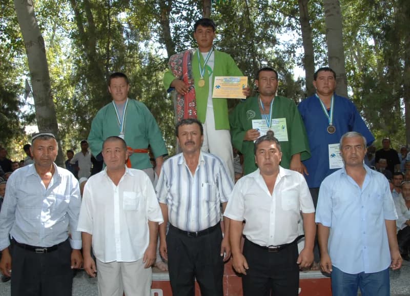 Athletes and officials posing at an outdoor sports competition ceremony