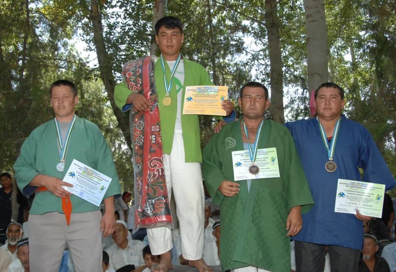 Athletes holding certificates and medals outdoors
