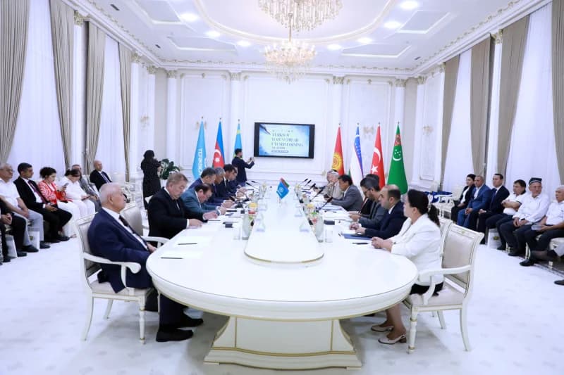 Delegations gather around a large conference table in a meeting hall