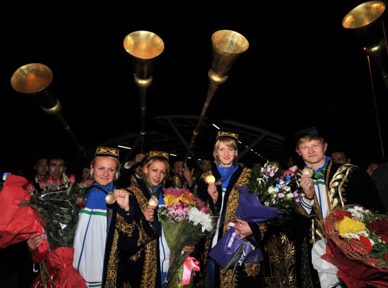 Группа спортсменов с медалями и цветами