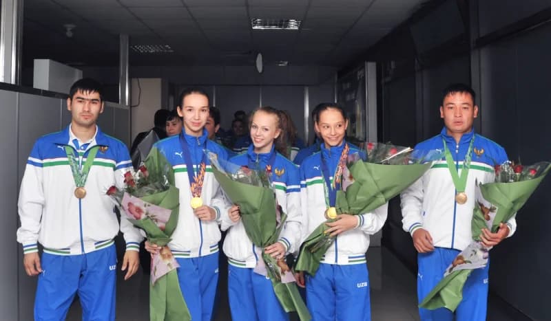 Спортсмены в спортивной одежде с медалями и букетами цветов