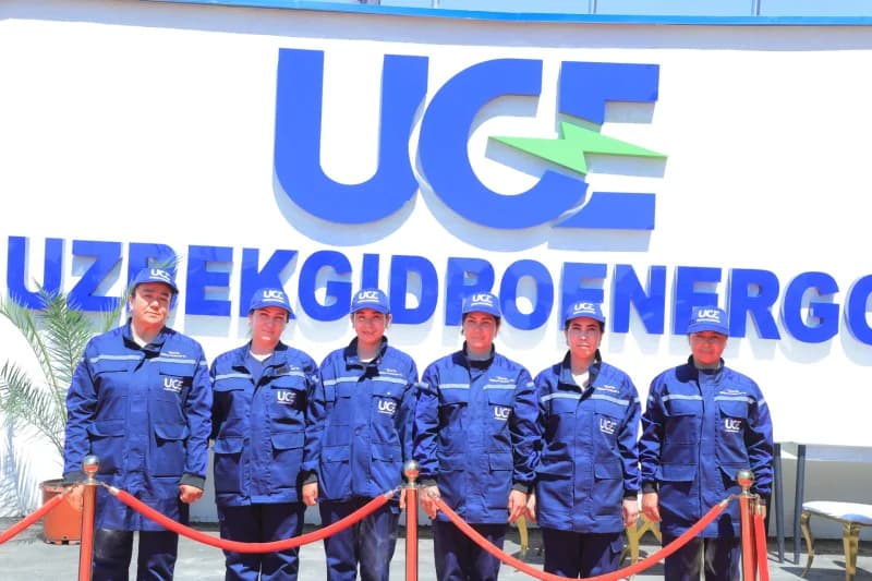 Group of workers in uniform standing before a sign