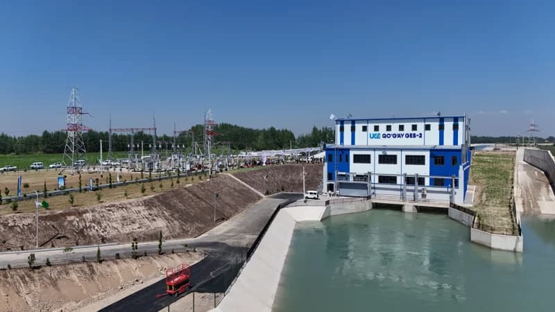 Industrial facility with a building bearing text UGE QO'G'AY GES-2 beside a water channel