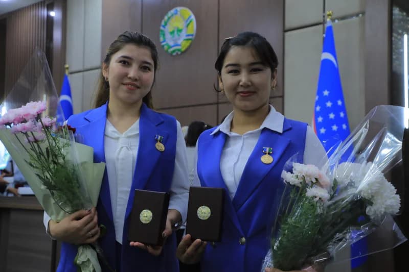 Поза двух молодых женщин с наградами и цветами