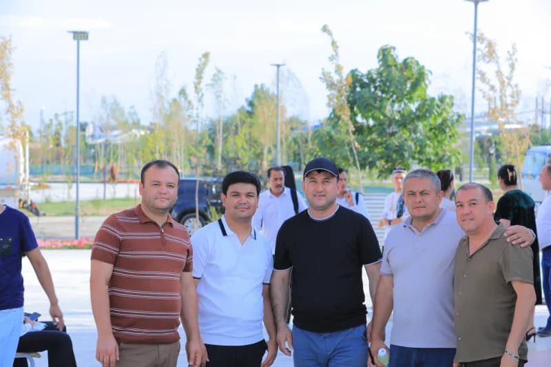 Группа мужчин позирует на открытом воздухе