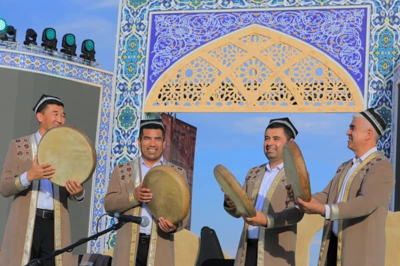 Men in traditional clothing performing with frame drums outdoors