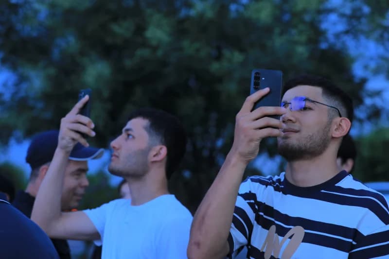 People taking pictures with mobile phones outdoors