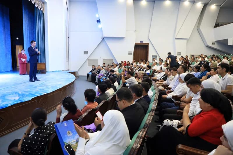 People gathered at a conference inside an auditorium