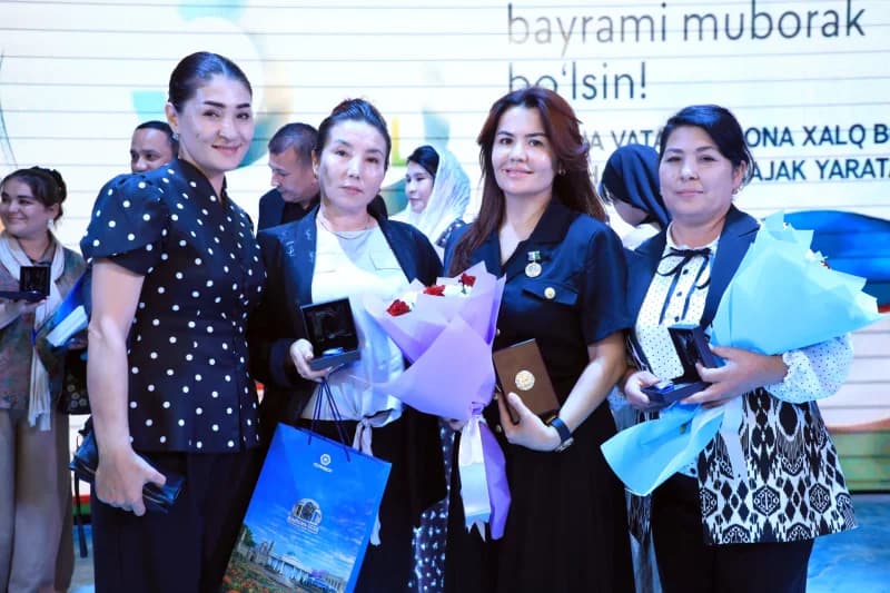 Group portrait of women holding small boxes and flowers indoors