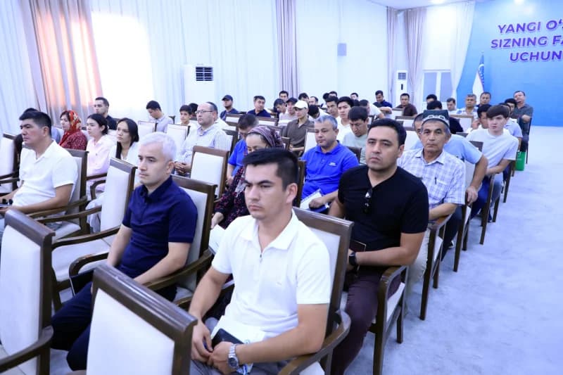 People seated in an auditorium listening attentively