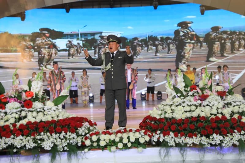 Man in military uniform singing on stage