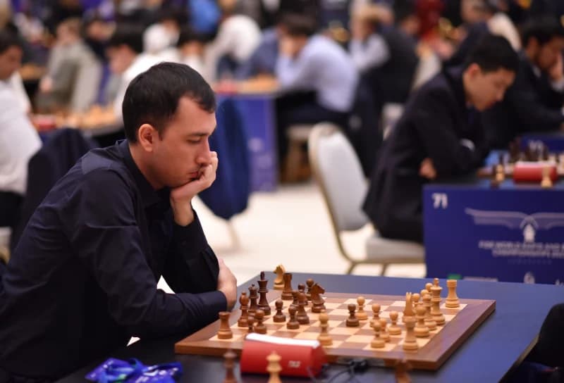 Participant focusing on chess game in competition hall