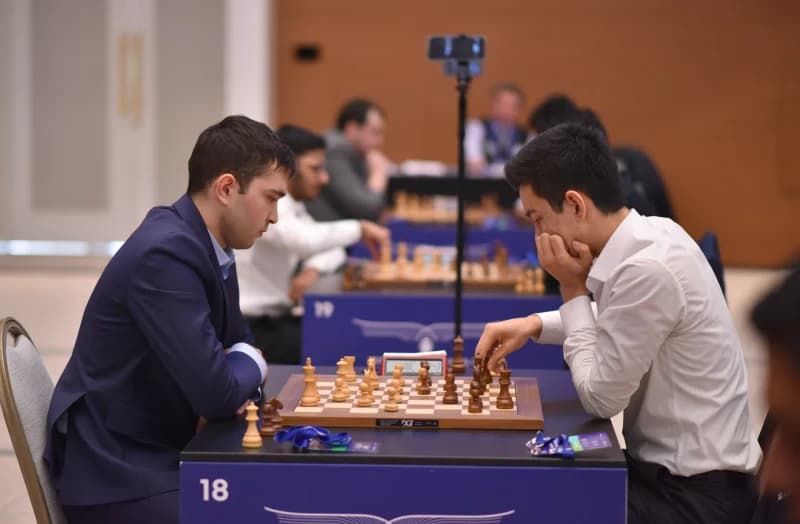 People playing chess at a tournament table