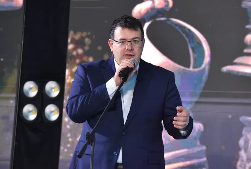 Мужчина, говорящий в микрофон на сцене