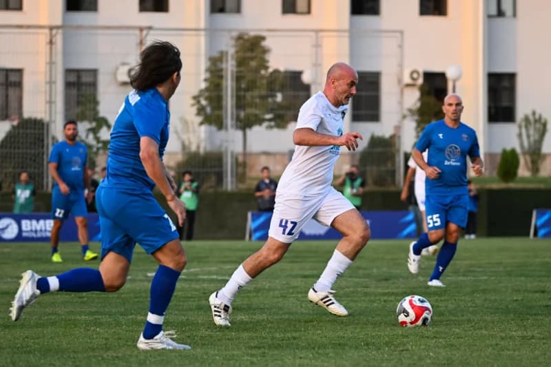 Players competing in a football match on a grass field