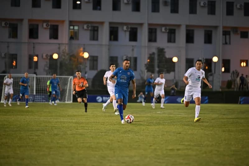 Players competing in a football match on a grass field