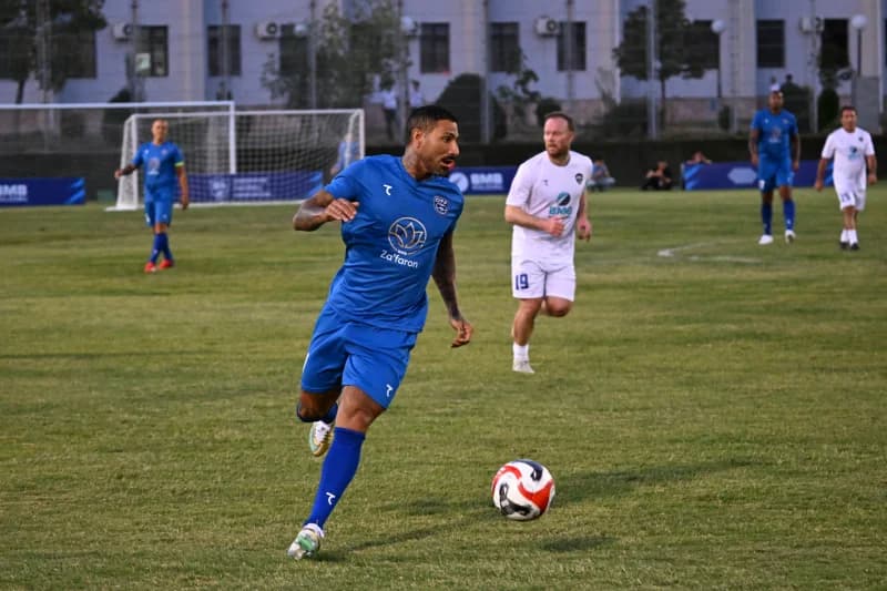 Soccer player running with ball on field