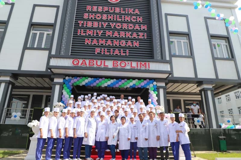 Medical staff gathered in front of a medical facility building
