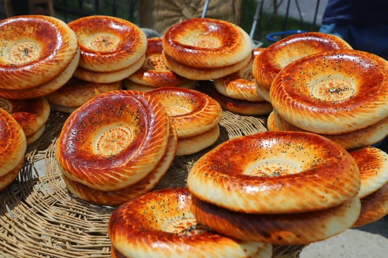 Freshly baked round flatbreads stacked on woven trays