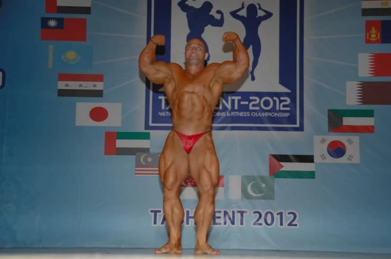 Male bodybuilder poses on stage during a competition